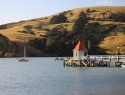 Molo v Akaroa. Každé ráno tu vyplová plachetnice s turisty na tuleně a tučňáky, v sezoně i na velryby. Ale jenom koukat, ne lovit!